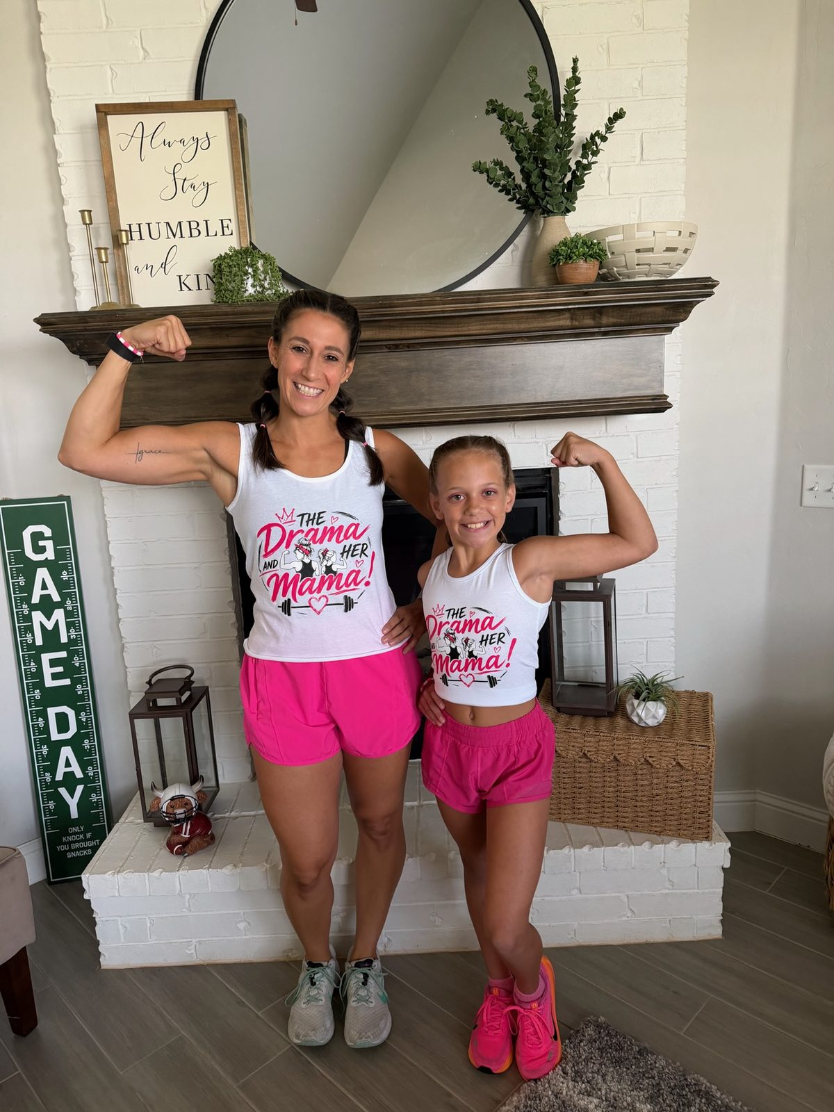 A mother and daughter in matching white tanks carrying the same full-color Drama and Her Mama transfer