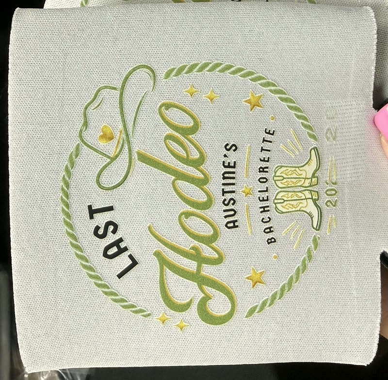 Two can koozies printed with the same round crest design, photographed against white.