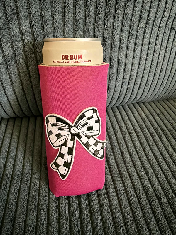 A hot pink slim koozie with a checkered bow patch.