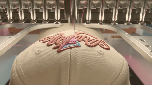 Placeholder image: a needle stitching thread into a cap crown